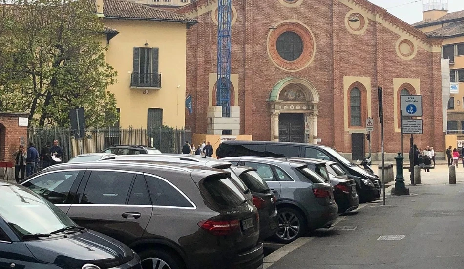 Cars parked near Santa Maria delle Grazie in Milan, with the church visible in the background.