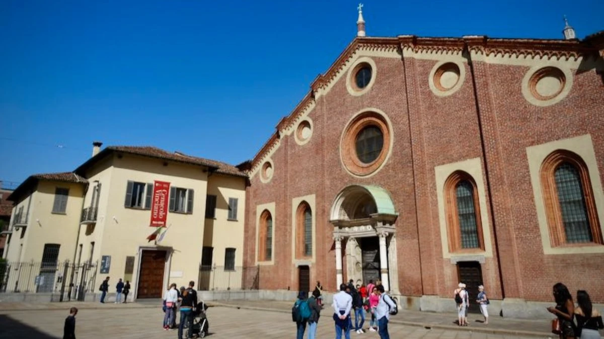Visitors and tourists gathered outside Santa Maria delle Grazie, admiring its historic entrance and architectural design.