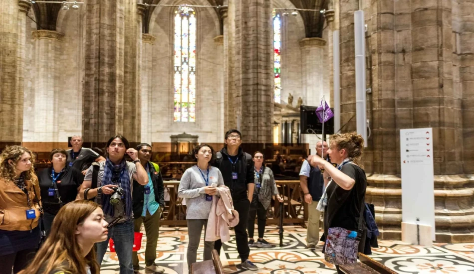 Tour group exploring the interiors of an Italian cathedral.