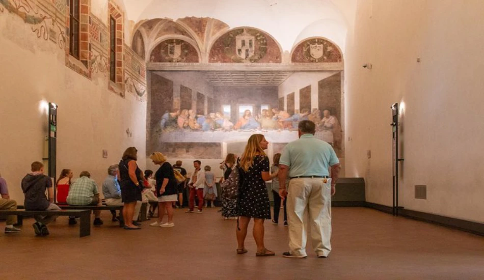 Tourists standing and sitting while admiring The Last Supper in Milan.